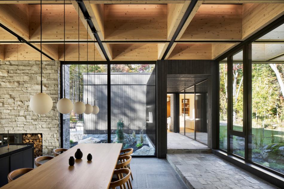 Interior living room with coffered timber ceiling and stone fireplace facing the lake