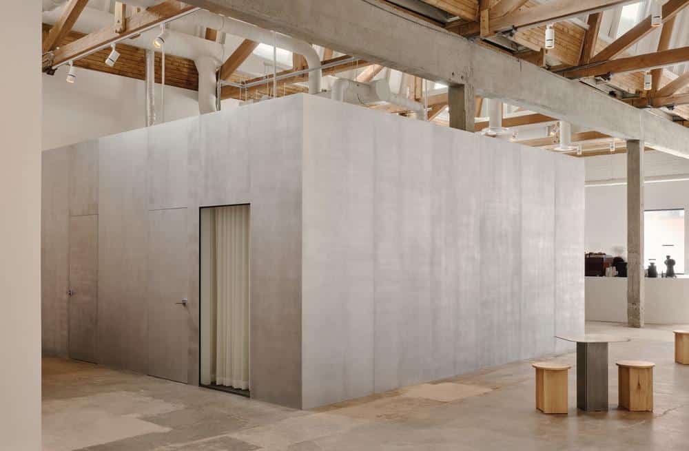 Brushed metal cube organizing circulation inside the gallery
