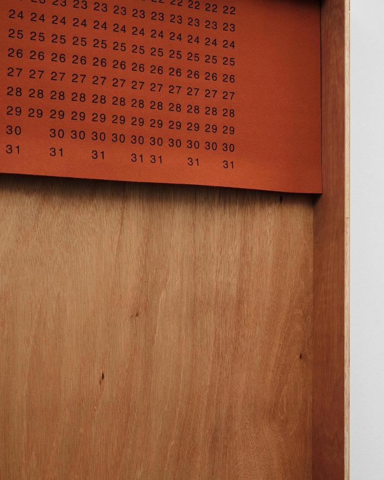 Calendar roll hung on right frame displaying neutral numeric typography