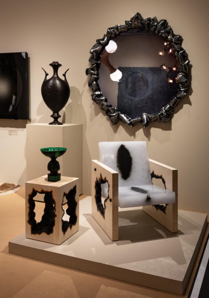 Exhibition view showing Burnout furniture and Custodians ceramics with gallery signage