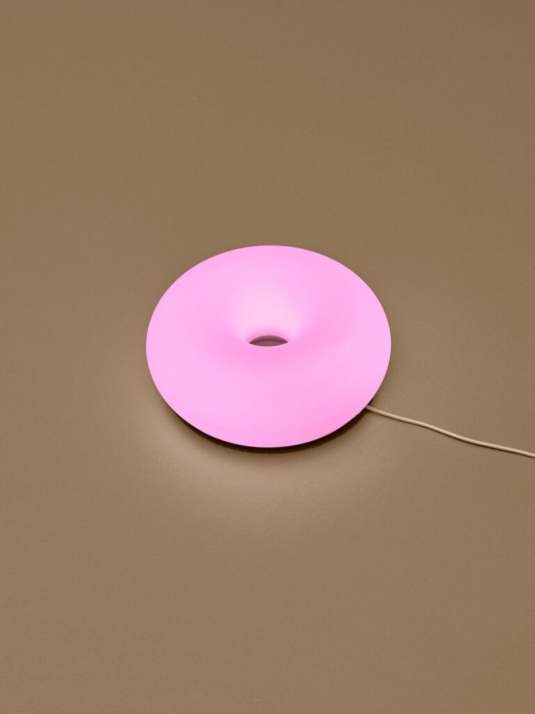 Close view of the smart donut lamp glowing in matte white glass