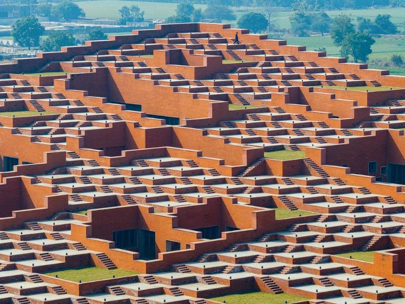 Ground-level view of the stepped terraces rising behind lawn grids and low brick edges