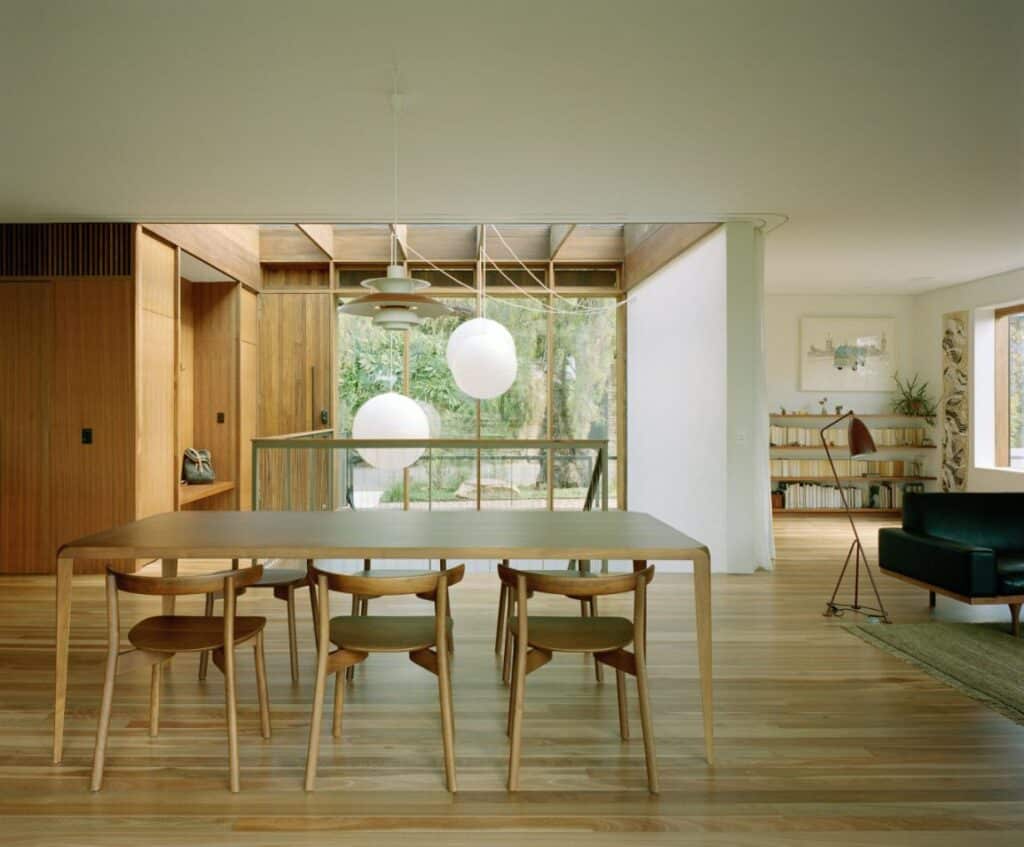 Living room opening to balcony and treetop views