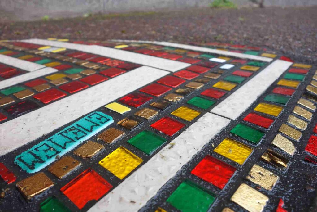 Close-up of a pothole patch transformed into a geometric ceramic inlay by Ememem