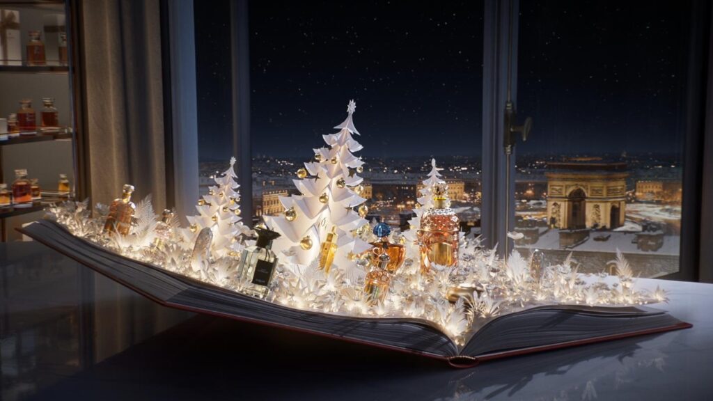 Open book transformed into illuminated paper forest with Guerlain products and white Christmas trees