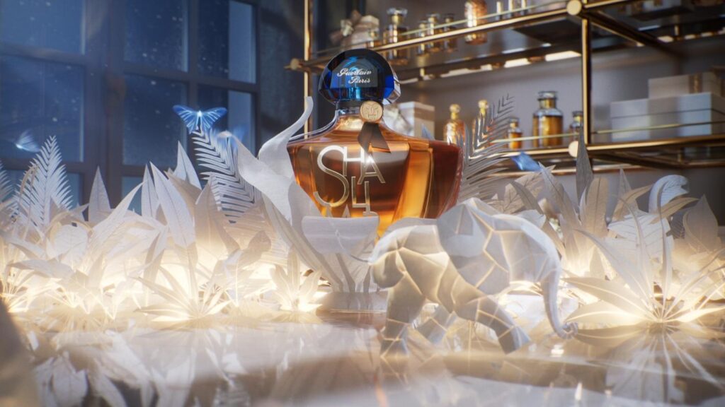 Shalimar bottle framed by illuminated white origami plants and paper elephant in perfumer’s workshop