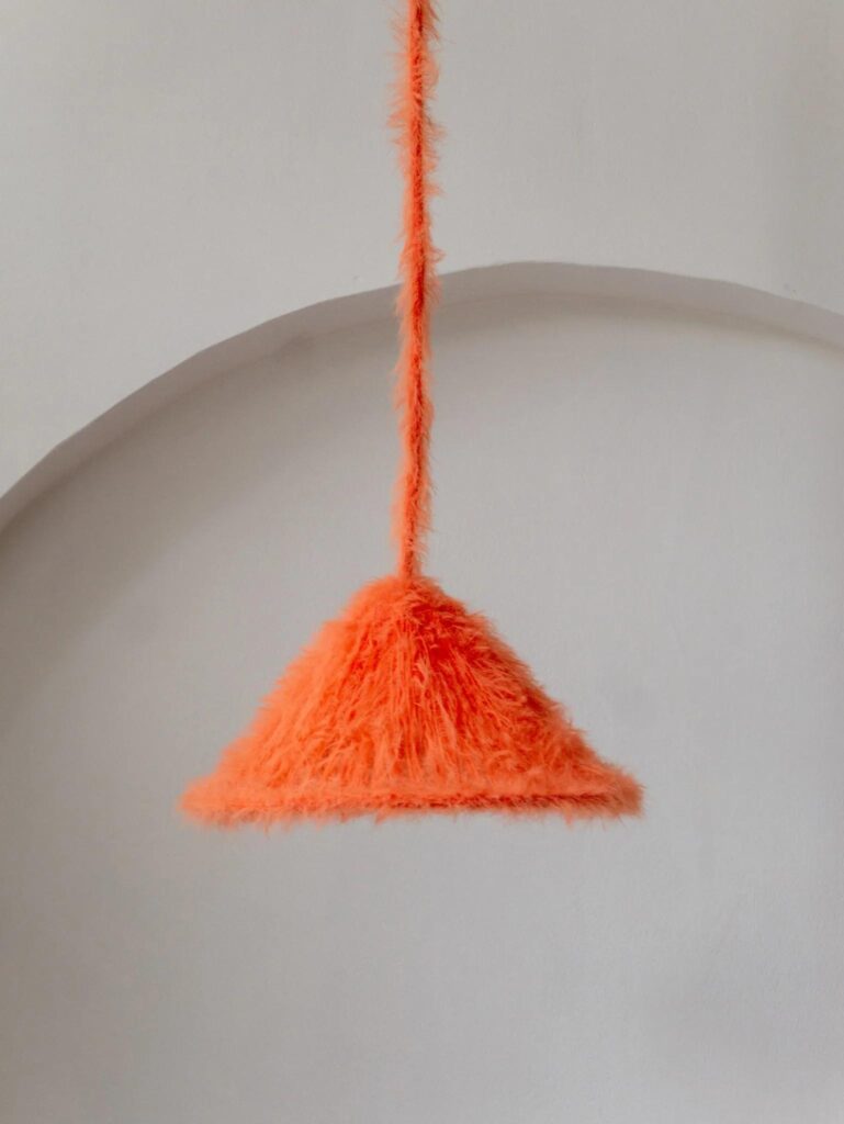 Orange furry knitted pendant lamp suspended