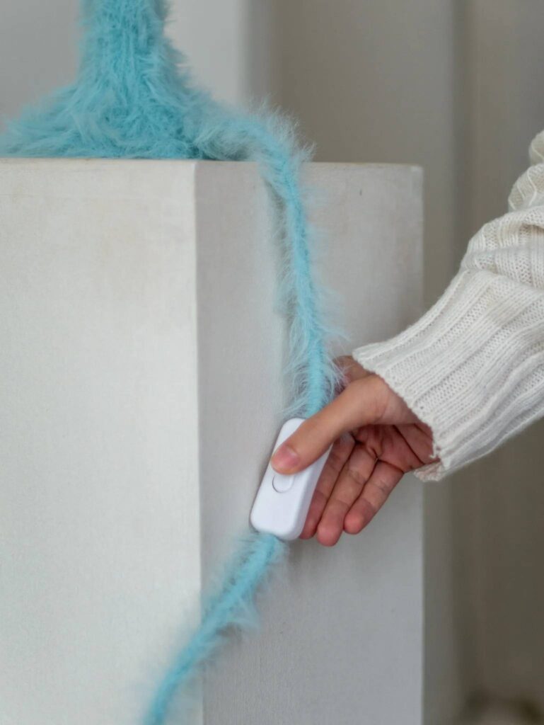 Close-up of pale blue furry knitted pendant lampshade showing soft fiber texture