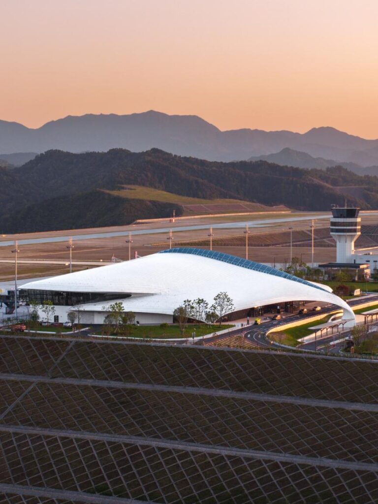 Elevated sunset view of Lishui Airport terminal and control tower with mountain landscape behind