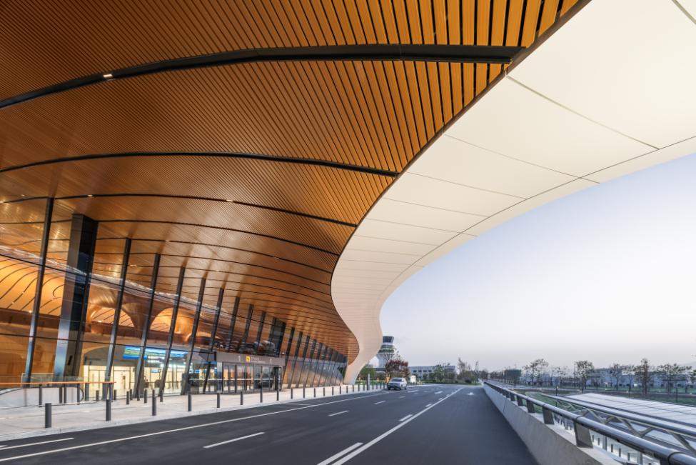 Exterior drop-off canopy showing curved soffit and glazed terminal facade