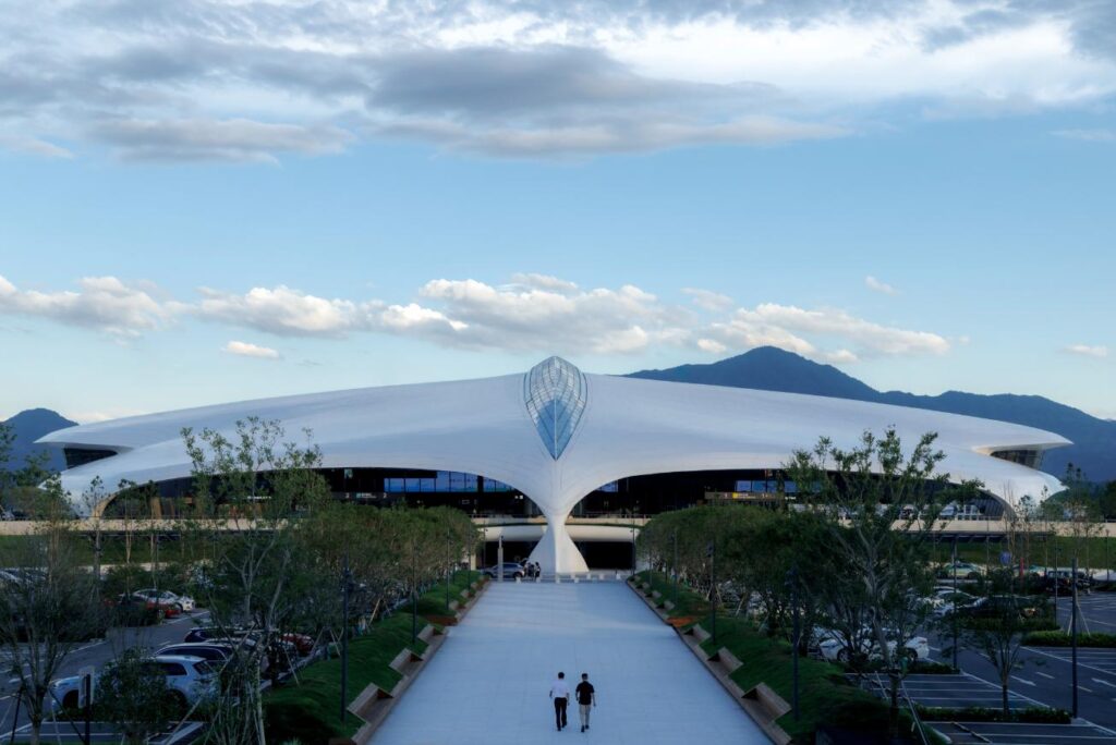 Front approach view of Lishui Airport terminal by MAD with central promenade and mountain backdrop