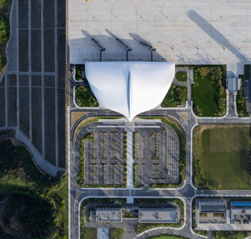 Top-down aerial view of terminal roof, parking layout and central access promenade