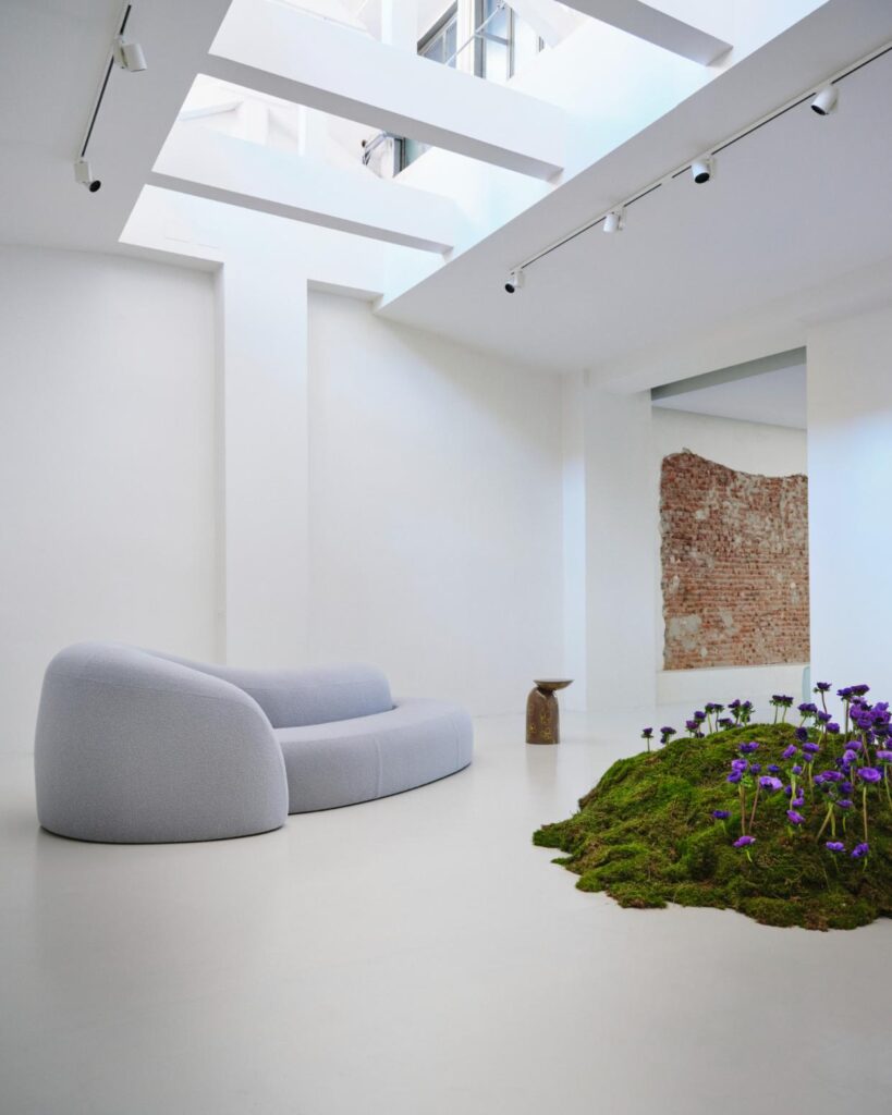 Gallery view with skylight above the sofa and planted mound at Secolo Milano Design Week presentation