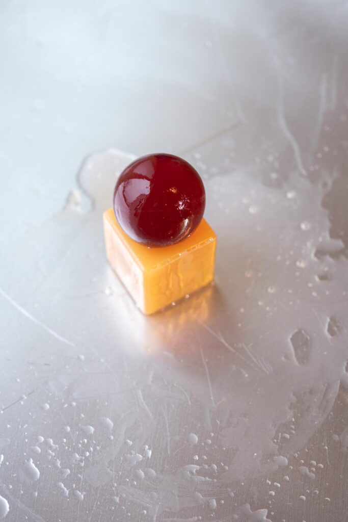 Amber colored soap sphere on natural tray
