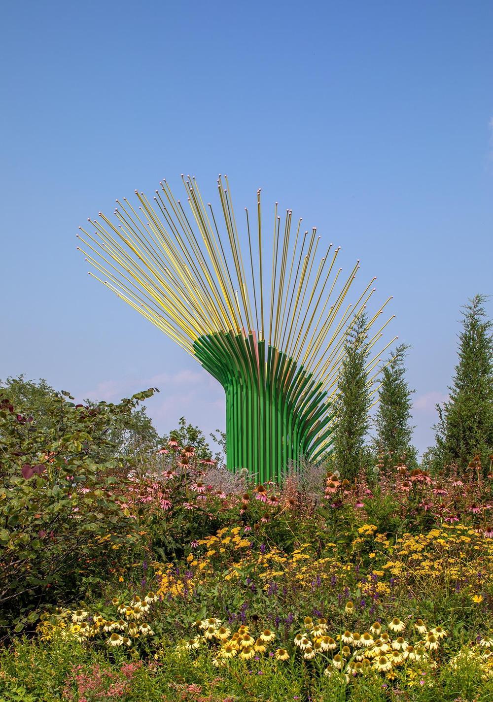 Pink to green gradient steel tubes forming Chorus Ventus sculpture inspired by prairie grasses