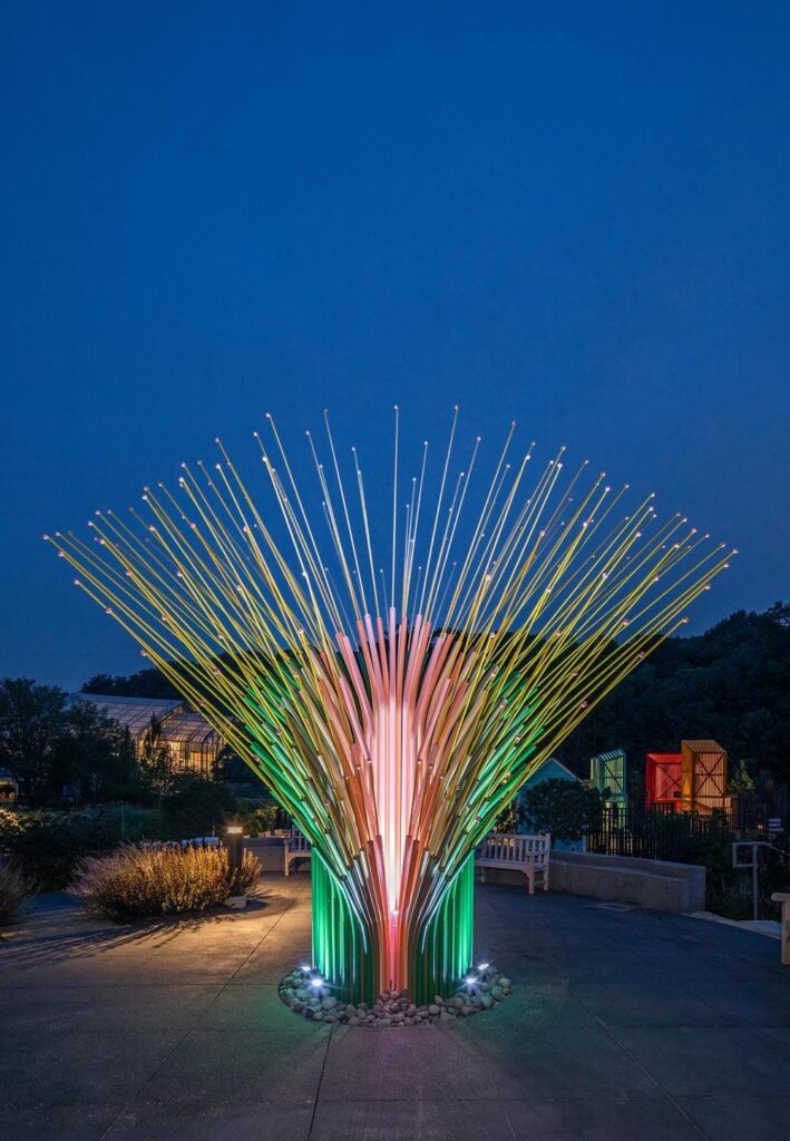 Night view of Chorus Ventus installation illuminated with RGB lighting in Omaha
