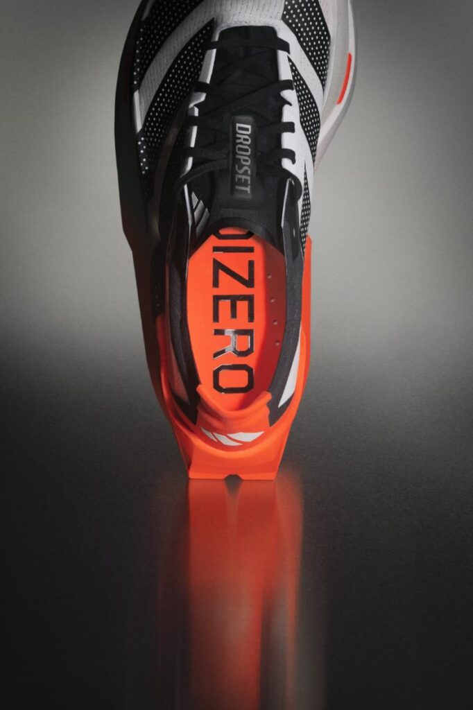 adidas Adizero Dropset Elite shown in three-quarter view highlighting striped upper and orange rearfoot platform