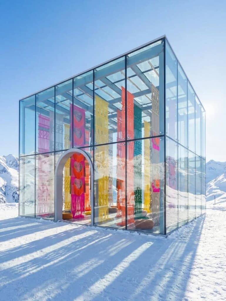 From Desert Sand to Alpine Snow by Milla Novo shown inside a transparent glass pavilion on an Alpine snowfield