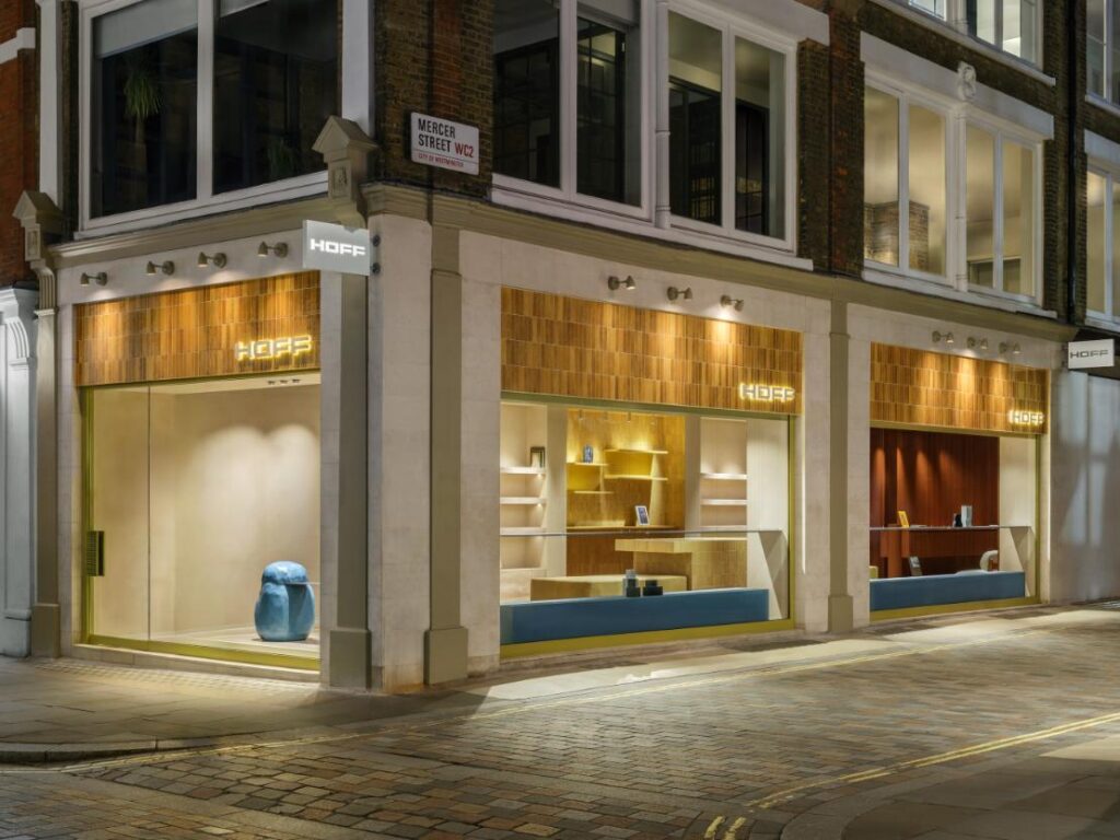 Exterior facade of HOFF London flagship store featuring ochre ceramic lintel and stone portals framing shop windows