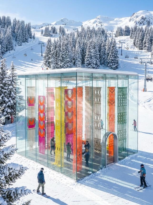 Glass pavilion concept in snowy ski landscape and visitors outside