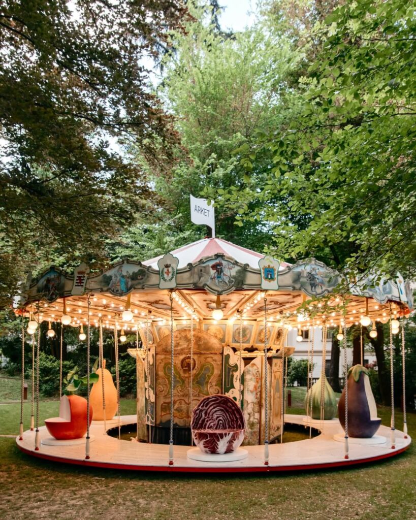 Arket and Laila Gohar transform carousel with oversized food sculptures in Milan