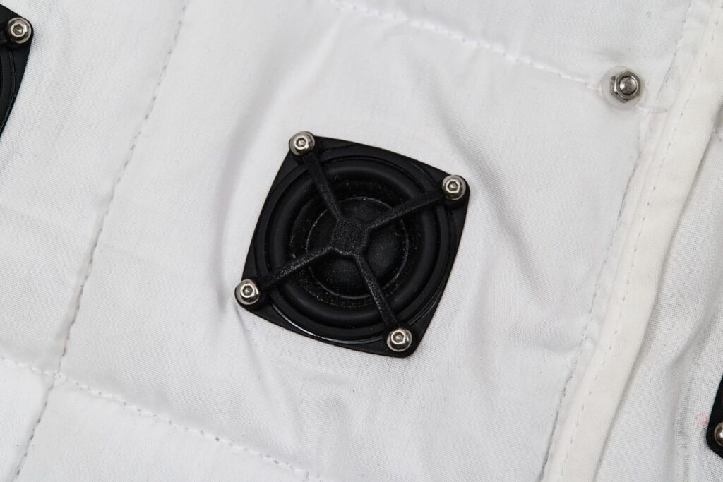 Detail of the speakers mounted inside laser-cut openings in the garment