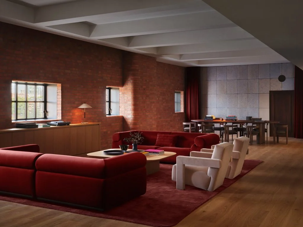 VIP green room with exposed brick walls, red sofas and large communal dining table