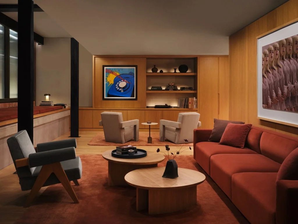 Green room with timber walls, red seating and framed music artwork