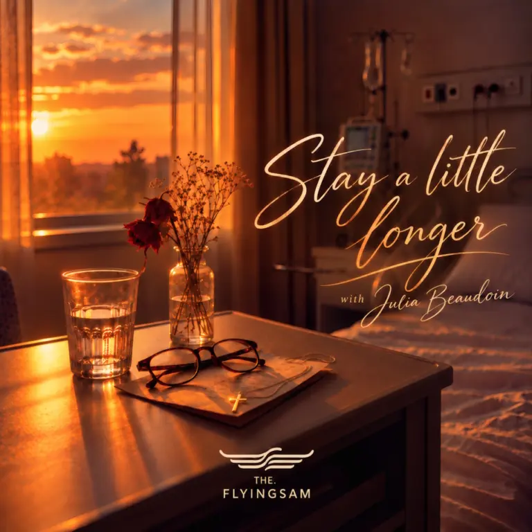 Orange sunset light falls across a bedside table holding a glass of water, flowers, eyeglasses and a book.